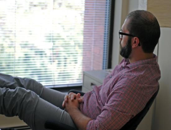 A male in a couselling office looking out the window waiting to receive Langley Community Service's Free Community Counselling Program